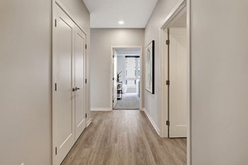 an empty hallway with white doors and a hallway view of a house